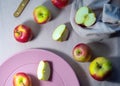 Red apples on pastel pink plate with knife on purple background, Royalty Free Stock Photo