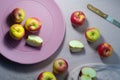 Red apples on pastel pink plate with knife on purple background, Royalty Free Stock Photo