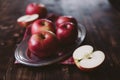 Red apples on plank wooden table