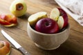 Red apples slices in a bowl on wooden rustic table