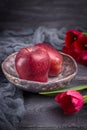 Red apples and spring flowers tulips on a dark background. Rustic style, free space Royalty Free Stock Photo