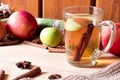 Red apples on a wooden board, glass cup of herbal or tea and cinnamon. Royalty Free Stock Photo