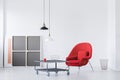 Red armchair and metal coffee table in a modern daily room interior. Real photo