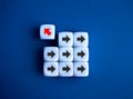 Red arrow go out from group of right way arrow direction symbol on white dice blocks, blue background. Royalty Free Stock Photo