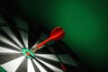 Red arrow hitting target on dart board against green . Space for text Royalty Free Stock Photo
