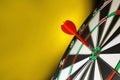 Red arrow hitting target on dart against yellow background. Space for text Royalty Free Stock Photo