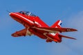 A Red Arrows Hawk flies against a bright blue sky