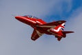 A Red Arrows Hawk flies against a bright blue sky