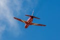 A Red Arrows Hawk flies against a bright blue sky