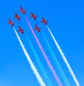 The Red Arrows jets with white smoke and clear blue sky