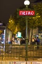 Red art-deco metro sign in Paris at night