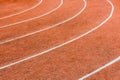 A red athletics track with white lines delimiting the lanes Royalty Free Stock Photo