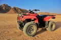 Red ATV in a desert with mountains view Royalty Free Stock Photo