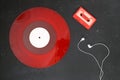 Red Audio cassette and Red vinyl record on a black background. Retro style. Top view. With White headphones . Royalty Free Stock Photo