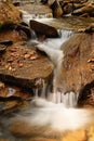 Red autumn leaf lying on wet stone  near a waterfall Royalty Free Stock Photo