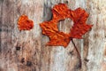 A red autumn sheet with heart on a wooden subsoil