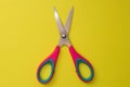 Red baby scissors on a yellow background Royalty Free Stock Photo