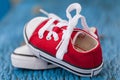 Red baby sneakers on wooden blue background Royalty Free Stock Photo