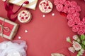 Red background with cupcakes, hearts, gifts, flowers. Copy space for valentines day greeting text