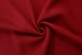 Red background of fabric from a piece of crumpled clothes