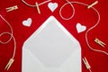 A red background from felt. A composition from heart, thread and clothespins. Frame from envelope for writing. Background with