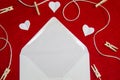 A red background from felt. A composition from heart, thread and clothespins. Frame from envelope for writing. Background with