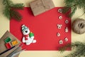On a red background fir-tree branches and wooden Christmas toys, snowman with gifts. Christmas greeting card, concept diy. Royalty Free Stock Photo
