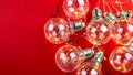 On a red background is a garland of light bulbs. Place for text. Royalty Free Stock Photo