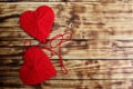 Two hearts of red color tied by a thread lie on a wooden background Royalty Free Stock Photo