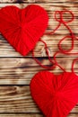 Two hearts of red color tied by a thread lie on a wooden background Royalty Free Stock Photo