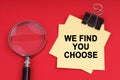 On a red background, a magnifying glass and a sticker with the inscription - We find you choose