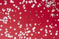 Red background with silver glitter selective focus. Christmas texture mockup