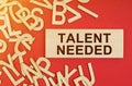 On a red background, there are wooden letters and a plate with the inscription -Talent Needed