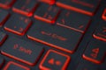 Red backlit computer keyboard macro shot of enter key