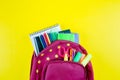 Back to school concept. Red backpack with different stationery on yellow background. Top view Royalty Free Stock Photo