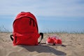 Red backpack and shoes on a beach background Royalty Free Stock Photo