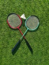 Red badminton rackets and shuttlecock lie on the artificial grass of a sports stadium. Royalty Free Stock Photo