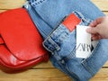 Red bag and jeans on hangers on wooden background with Zara tag, winter sales