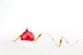 Red ball Christmas decoration with gold ribbon on snow isolated on white background. Space for your text Royalty Free Stock Photo