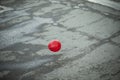Red ball flies over asphalt. Balloon outside