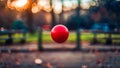 A red ball flying through the air in front of a park bench, AI Royalty Free Stock Photo