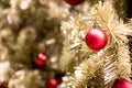 Red ball on gold branch of artificial chrismas tree background Royalty Free Stock Photo