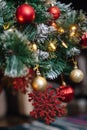 Red ball and shiny red snowflake on a Christmas tree with lights and bokeh Royalty Free Stock Photo