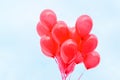 Red balloons towards a light blue sky, flying in the air