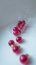 A dynamic composition for a festive mood, consisting of bright red Christmas balls and a transparent sparkling wine glass