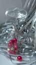 A dynamic composition for a festive mood, consisting of bright red Christmas balls and a transparent sparkling wine glass