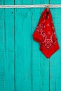 Red bandana and key hanging by rope on antique teal blue background