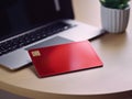 Red bank credit card on office desk with laptop AI