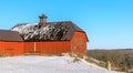 Red barn with black roof on winter snowy hill Royalty Free Stock Photo