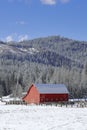 Red barn under a blue sky in winter. Royalty Free Stock Photo